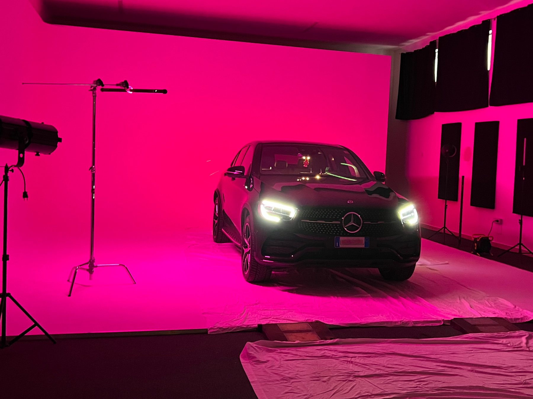 Set fotografico con automobile su limbo illuminato in magenta